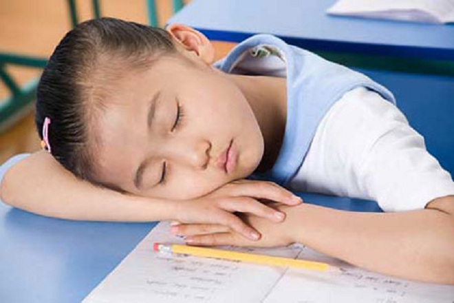 bé gái ngủ gật trên bàn học